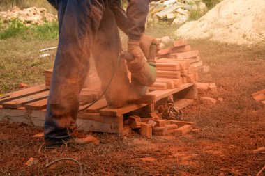 Radyal testere ile turuncu tuğla kesme işçi