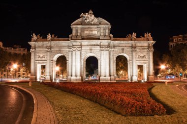 Madrid, İspanya; 08 / 05 / 2020: Puerta de Alcal 'ın doğu perdesinin gece fotoğrafları ve kırmızı bir bahçe