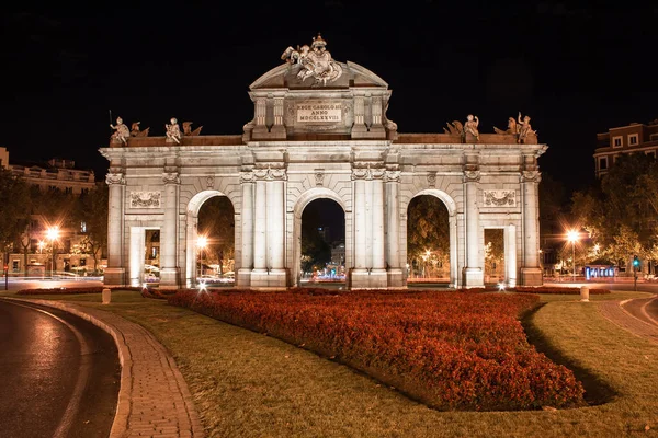 Madrid, İspanya; 08 / 05 / 2020: Puerta de Alcal 'ın doğu perdesinin gece fotoğrafları ve kırmızı bir bahçe
