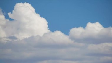Bulut birikimlerinin kısa bir çekiminin 4K zamanlaması mavi gökyüzü arka planına doğru hareket ediyor ve dalgalanma oluşturuyor