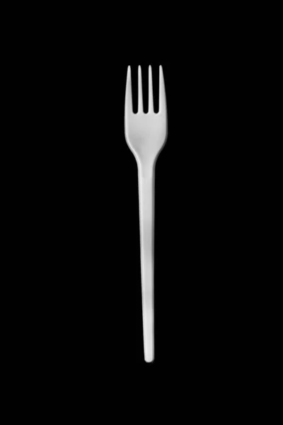 Пластиковая вилка для еды на черном фоне — стоковое фото