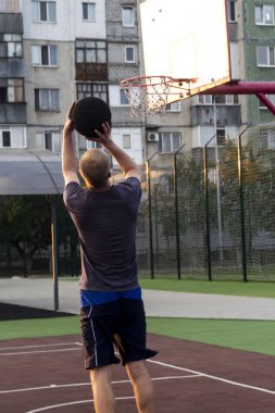 adam basketbol oynar bir atlama bir sepete bir top atar