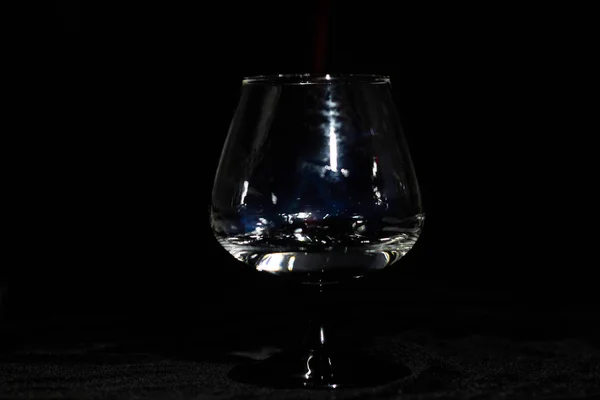 黒い背景だけで燃えるサンブカを持つコニャックガラス — ストック写真