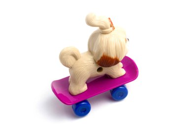 Beyaz arka planda pembe kaykaylı bir çocuk köpeği.