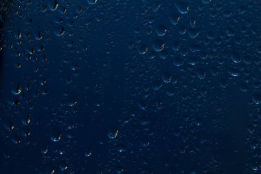 Pencere camlarındaki yağmur damlaları mavi arkaplandaki doğal yağmur damlaları..