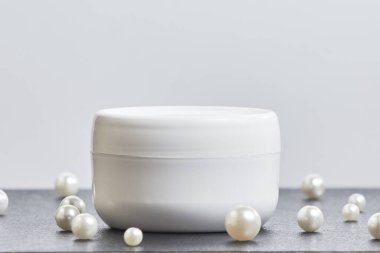 Gri arka planda beyaz kozmetik inci kavanozu. çoklu uzay. Model modeli. yan görünüm