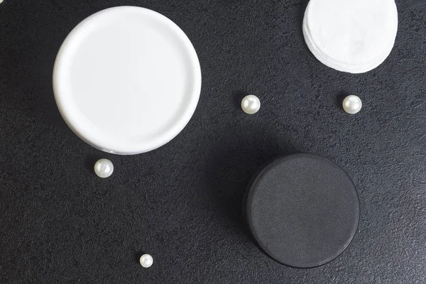 Vit och svart burk kosmetika för bad bomull pärla diskar på ett svart bord. Kopieringsutrymme. Förlöjligande. Ovanifrån. platt äggläggning — Stockfoto