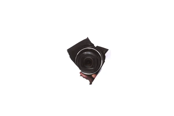 Fotokamera genom ett hål i papper på isolera vit bakgrund. närbild, kopiera utrymme — Stockfoto