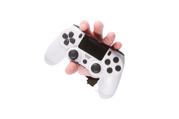 Man hand med en gamepad genom ett hål i papper på isolera vit bakgrund. nära kopieringsutrymme — Stockfoto