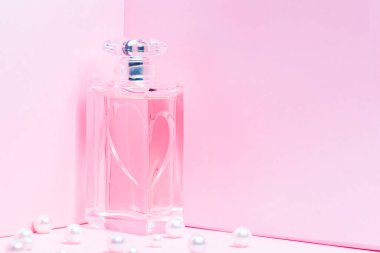 Pembe arkaplan fotokopi alanında incili pembe parfüm şişesi. Robot görünümü, yatay yönelim, modelle