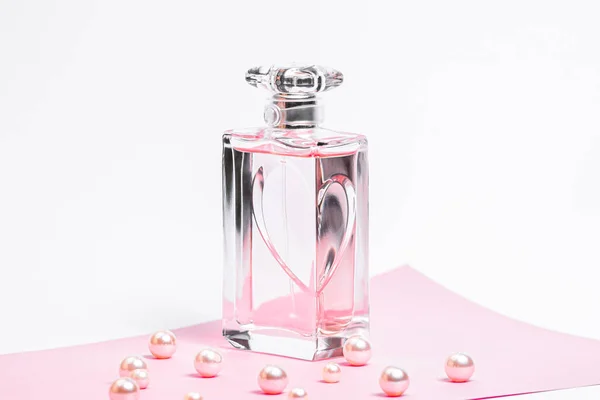 Garrafa de perfume rosa com pérolas em uma folha rosa em um espaço de cópia de fundo branco. bot view, mockup — Fotografia de Stock