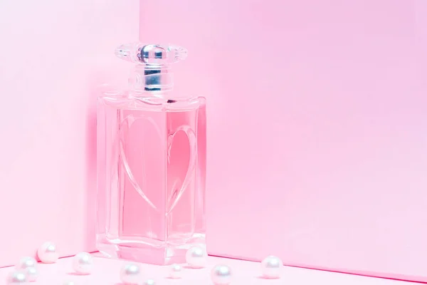 Pink perfume bottle with pearls on a pink background copy space. bot view, horizontal orientation, mock up — Stock Photo, Image