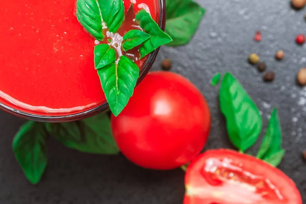 Suco de tomate com temperos tempero manjericão em uma mesa preta. espaço de cópia, close-up, orientação horizontal, vista superior — Fotografia de Stock