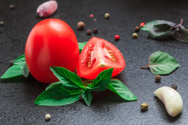 Pomodoro con spezie con basilico su un tavolo nero. spazio di copia, primo piano, orientamento orizzontale — Foto Stock