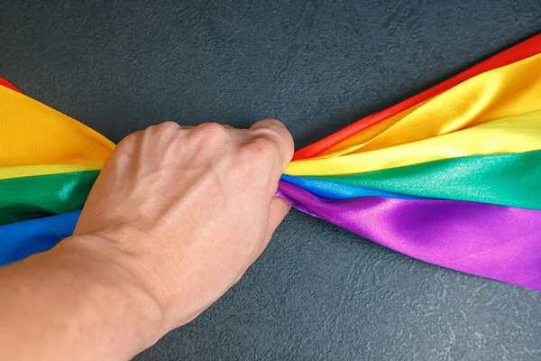 Mężczyzna ręka ściskając lgbt tęcza flaga za pomocą jak dla uczcić homoseksualny, gej, Lesbijki i pojęcie — Zdjęcie stockowe