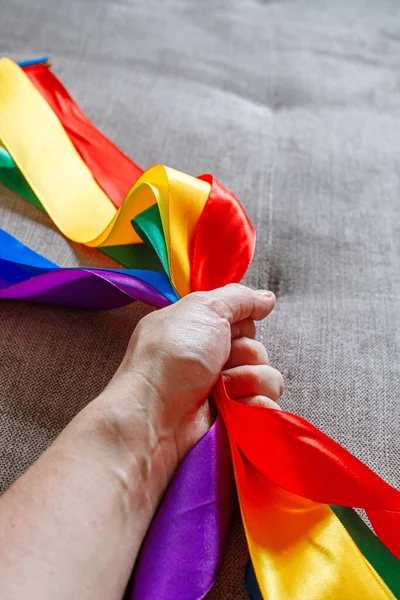 Band i lgbt regnbåge flagga färg i manlig hand med hjälp av hur man firar homosexuell, gay, lesbisk och koncept — Stockfoto