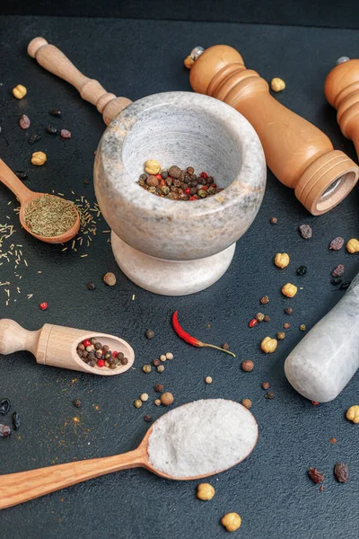 Malta di pietra con pepe e cucchiai di legno con spezie sul tavolo — Foto Stock