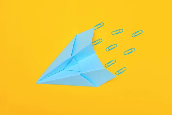 Минимализм, голубой бумажный самолет на желтом фоне, плоское пространство для копирования — стоковое фото