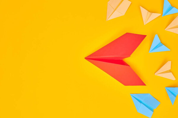 red paper plane and others on a yellow background. Leadership, teamwork and courage concept. Flat layer