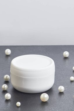 Gri arka planda beyaz kozmetik inci kavanozu. çoklu uzay. Model modeli. yan görünüm