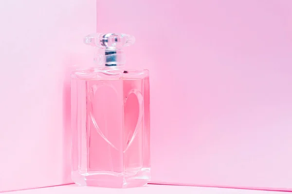 Różowa butelka perfum na różowym tle. widok na bot, orientacja pozioma — Zdjęcie stockowe