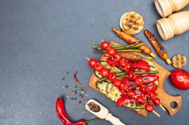 Tahtada ızgara sebzeler, siyah bir masanın üstünde, telif alanı, üst manzara.