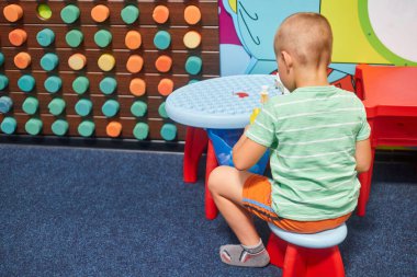 Küçük beyaz bir çocuk eğitim oyunları oynuyor.