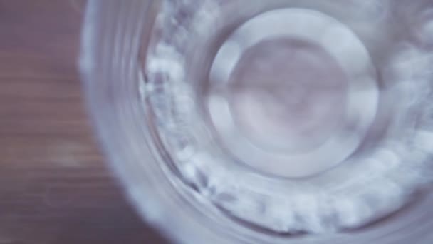 Ice flies into the glass on a dark background, close-up, top view — Stock Video