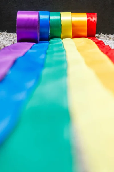 Band i regnbåge lgbt flagga färg i bobiner rullas ut med hjälp av hur man firar homosexuella, lesbiska och koncept — Stockfoto