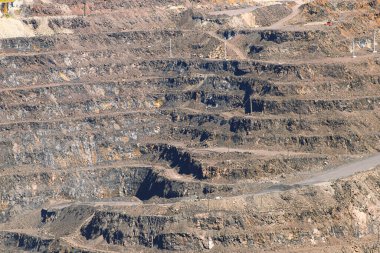 Demir cevheri ocağı, teraslı bir yol, madencilik endüstrisi. Maden ve taş ocağı ekipmanları.