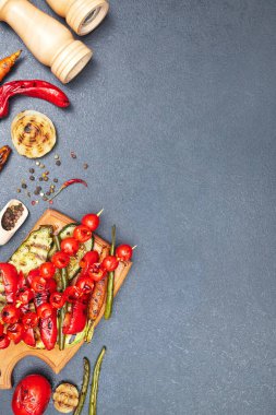 Tahtada ızgara sebzeler, siyah bir masanın üstünde, telif alanı, üst manzara.