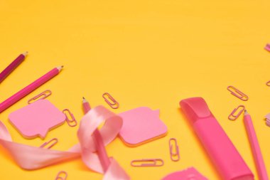 Minimalizm, okula dönüş konsepti, Pembe okul malzemeleri sarı arka planda, kopyalama alanı