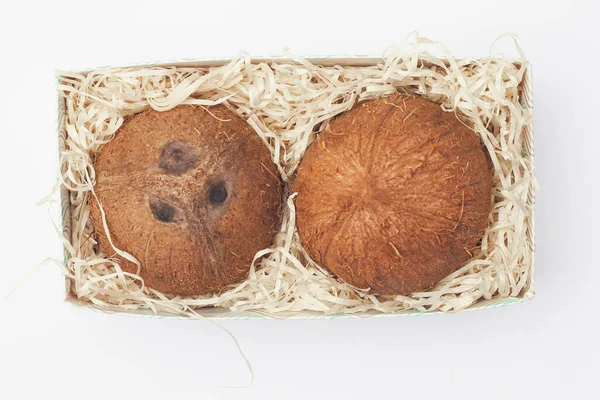Kokosnüsse in einer Schachtel auf weißem Hintergrund isolieren, kopieren Raum, flach — Stockfoto