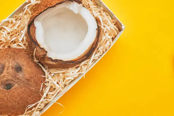 Em uma caixa de coco em um fundo amarelo isolado, copyspace, layout — Fotografia de Stock