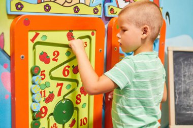 Küçük beyaz bir çocuk eğitim oyunları oynuyor.