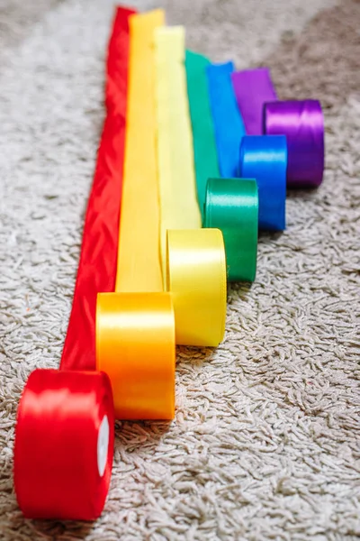 Band i färgen på lgbt regnbåge flaggan i bobbins rullas ut på mattan med hjälp av hur man firar homosexuella, homosexuella, lesbiska och begrepp — Stockfoto