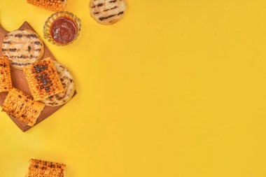 Sarı arka planda ızgara mısır sebzeleri, kopyalama alanı, düz yatak