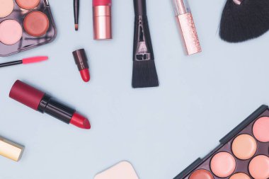 Mavi arka planda profesyonel kozmetik, makyaj malzemeleri ve aksesuarlar, güzellik, moda, alışveriş, düz yatak