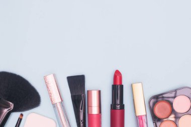 Mavi arka planda profesyonel kozmetik, makyaj malzemeleri ve aksesuarlar, güzellik, moda, alışveriş, düz yatak