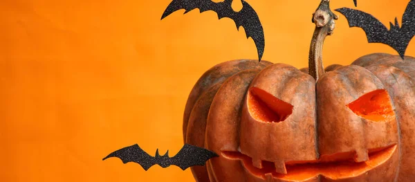 Zucche di Halloween e pipistrelli su sfondo arancione spazio copia — Foto Stock