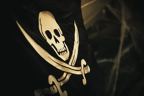 Drapeau crâne et os croisés sur le côté d'un bateau pirate — Photo