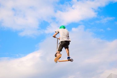 Adam parkta scooter kullanıyor..