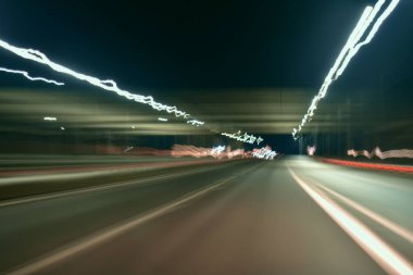 Gece şehrinin uzun soluklu neon renkleri. Sarı, kırmızı, mavi, siyah arka planda gri. Şehir görünümü.