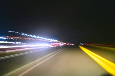 Sarı, siyah arka planda kırmızı çizgiler. Gece yolunun uzun pozlu fotoğrafı..