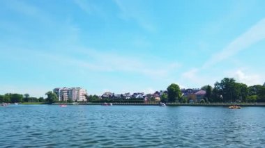 Yukarı Göl - yapay şehir havuzu, ünlü turistik eğlence merkezi ve güneşli yaz gününde Rusya 'nın Kalininingrad kentinde popüler dinlenme bölgesi. 4K 'da statik atış