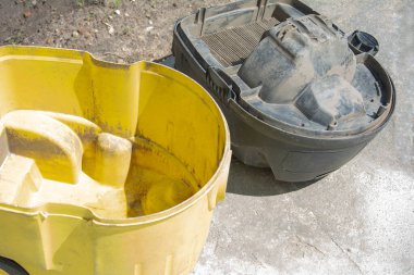 İşten sonra profesyonel elektrik süpürgesi. Parçalanmış kasa endüstriyel temizleyici. Elektrikli süpürge için çok kirli bir filtre. İnşaat enkazı toplamak için sarı tank.
