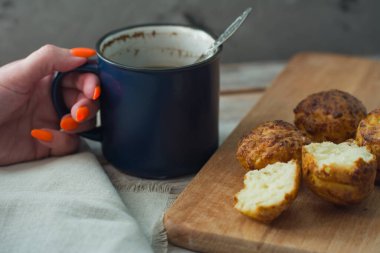 Kız büyük mavi bir fincandan kek ile kahve içiyor. Kahvaltı arkaplanı