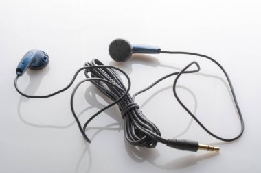 Beyaz camsı arka planda siyah kulaklık telleri. Taşınabilir aygıtlar için kullan: cep telefonu, müzik çalar, dizüstü bilgisayar veya tablet