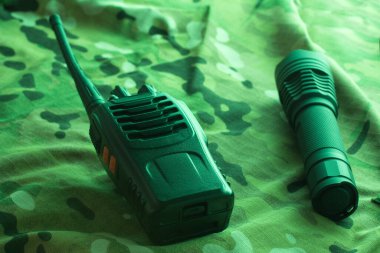 Kamuflaj arka planında yürüyüş ekipmanı. Telsiz ve telsiz.