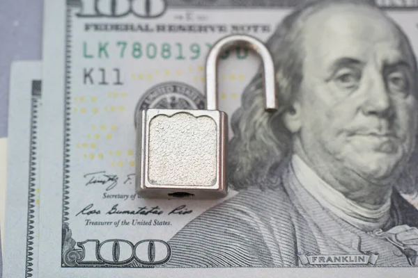 Opened security lock, open padlock on dollar bill background . Money protection concept. Banking security breach